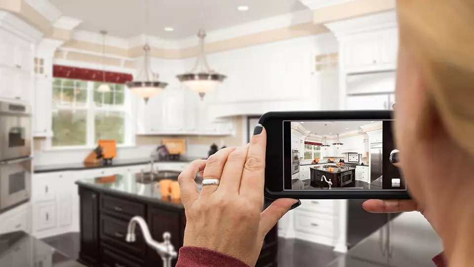 A person videotaping the staging of a home for sale.