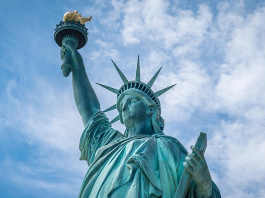 Close view of Statue of Liberty with blue sky and white clouds