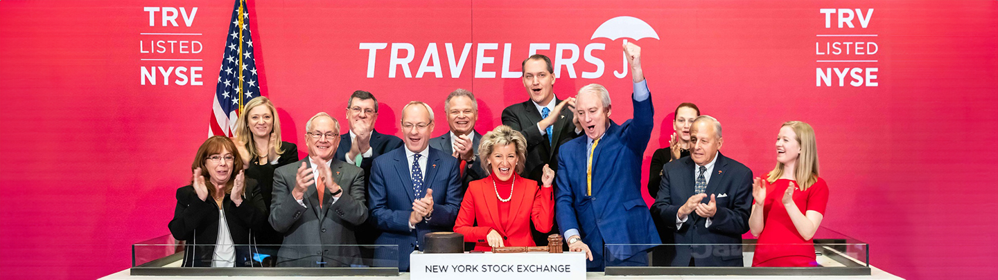 Joan Woodward and Travelers Institute team members ringing the bell at the New York Stock Exchange