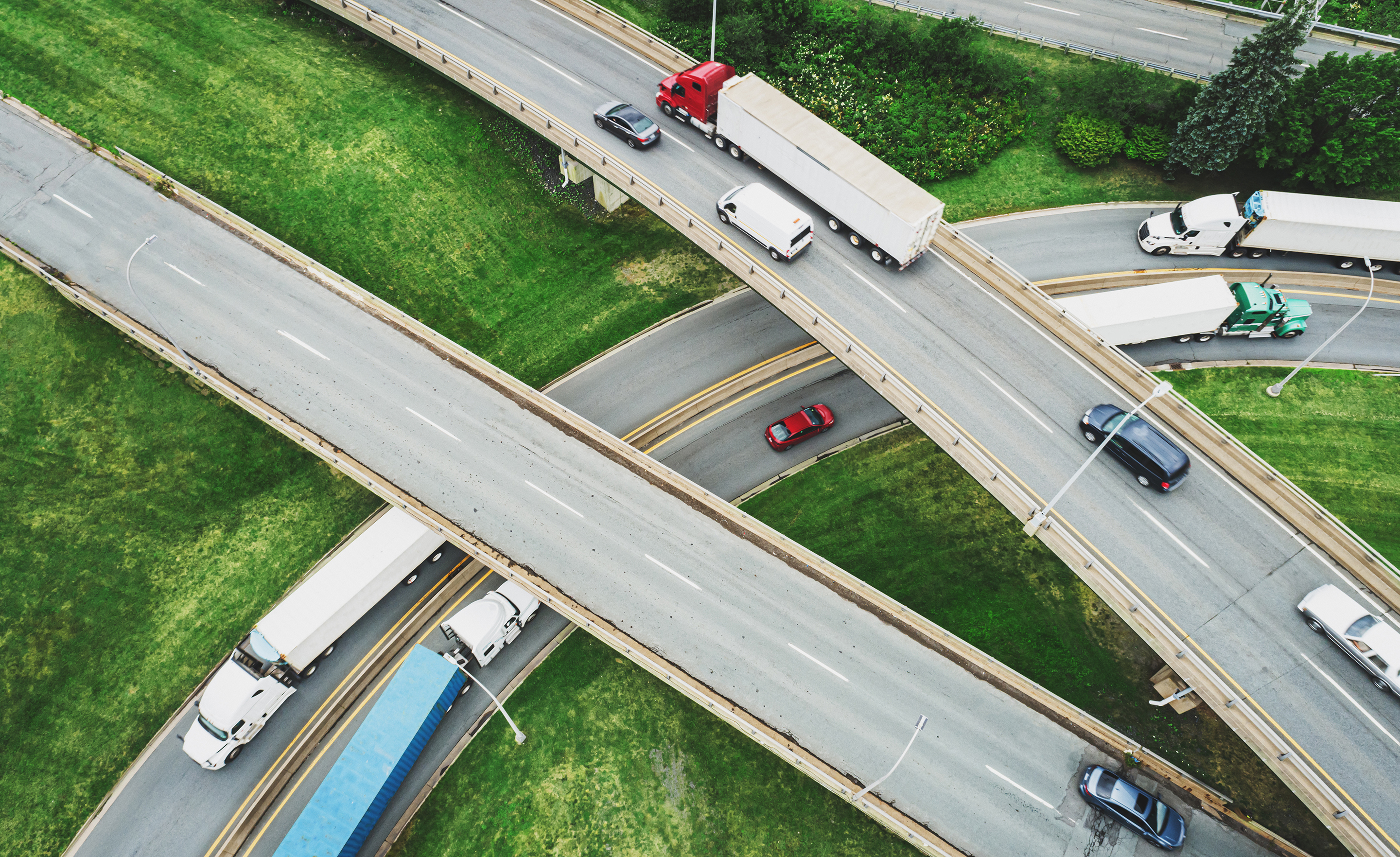 Aerial view of red semi-truck on a highway.