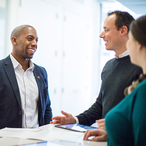 Personal insurance agent talking with a man and woman.