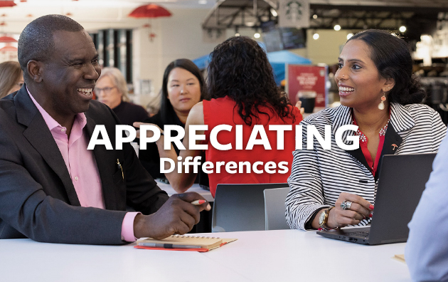 Group of diverse employees sitting at a table attending a conference.