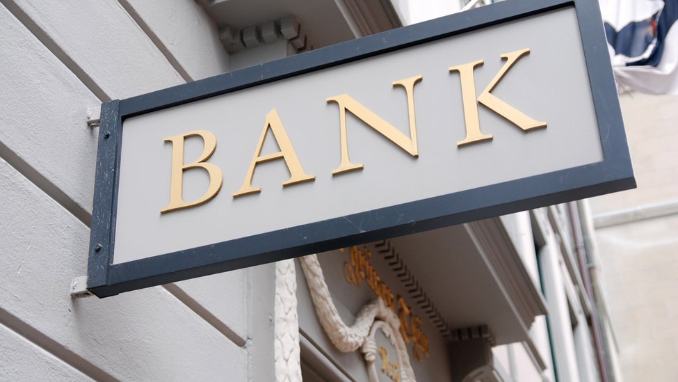 A bank sign attached to the side of a building.