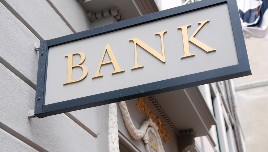 A bank sign attached to the side of a building.