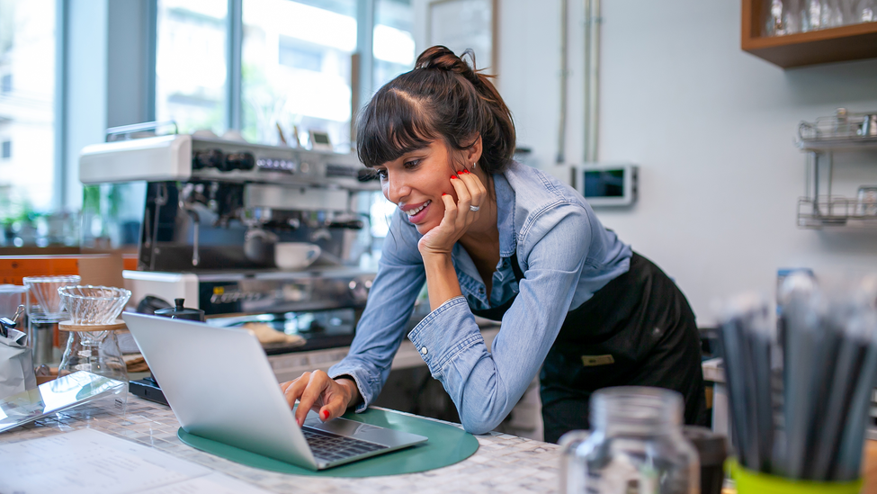 Female, blue shirt working on a laptop computer