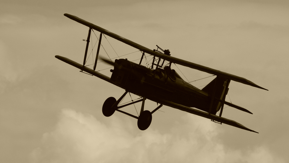 One of the first airplanes soars through the air. 