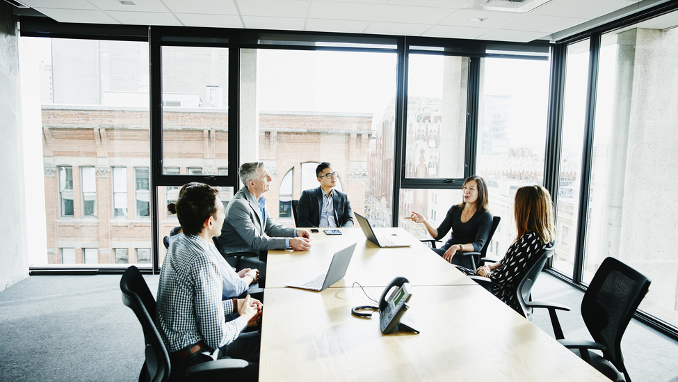 A group of business executives meet in a board room.