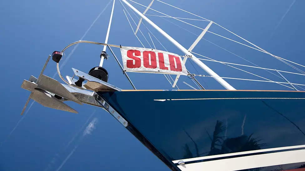 Front of a boat with sold sign.