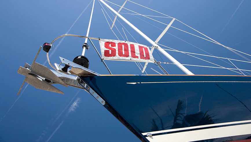 Front of a boat with sold sign.