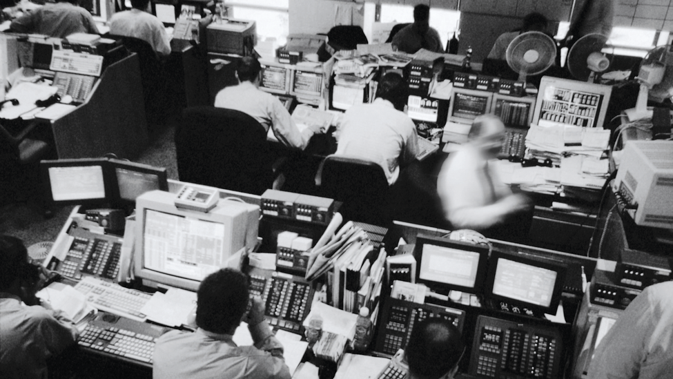 A packed work area with computers, desks and online workers.