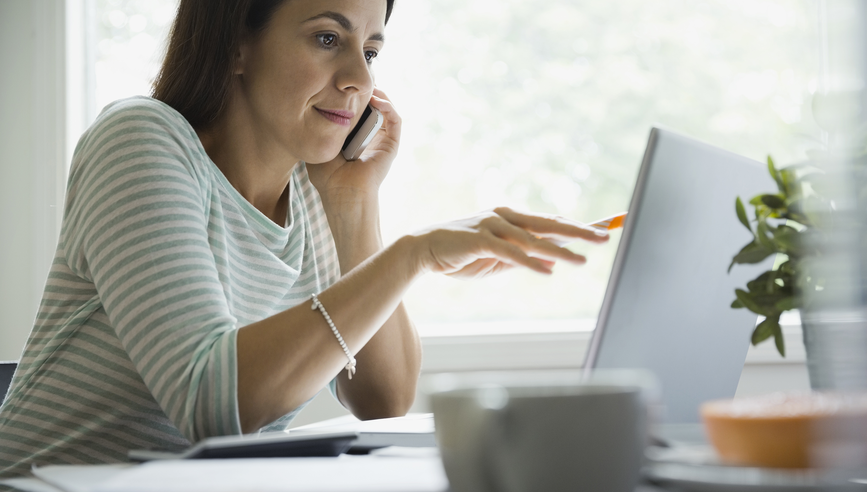 Businesswoman using technologies at desk in home office