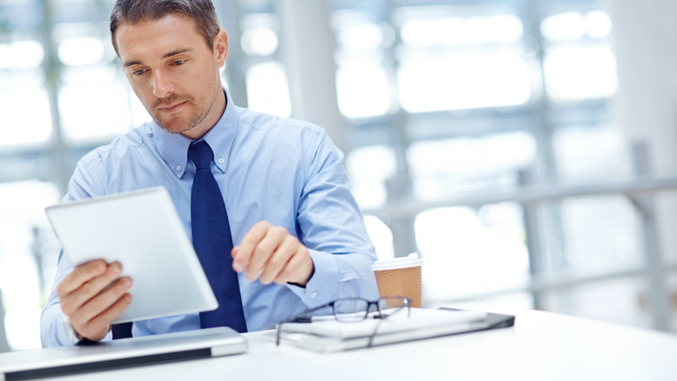 Businessman with tablet at office table