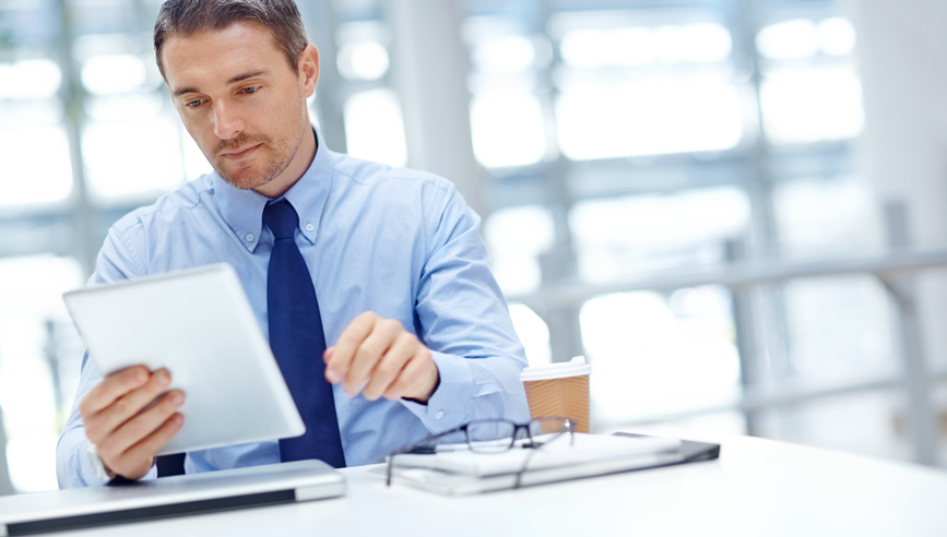 Businessman with tablet at office table