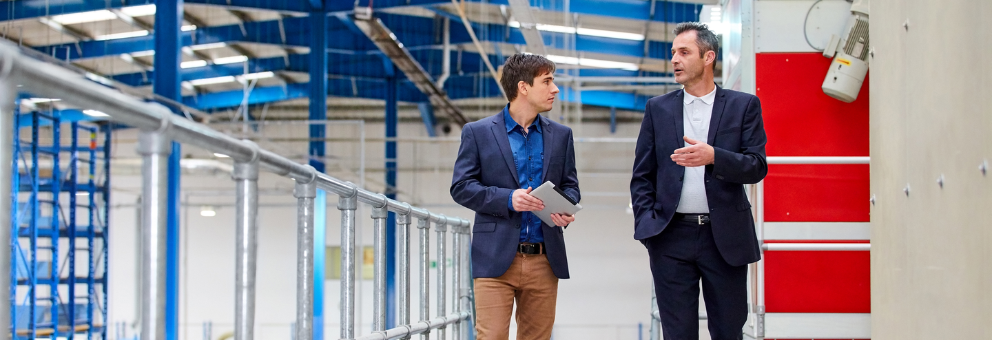 Business people walking and talking in factory.