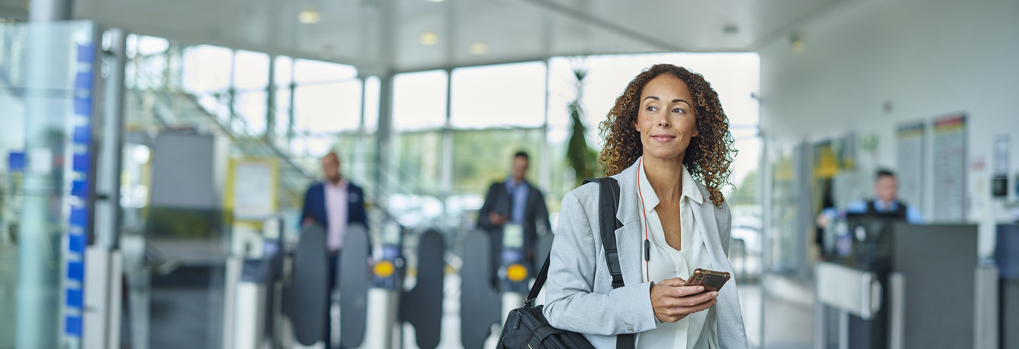 Businesswoman smiles as she arrives at an airport.