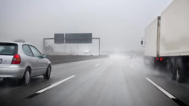 Cars driving in rain and wind.