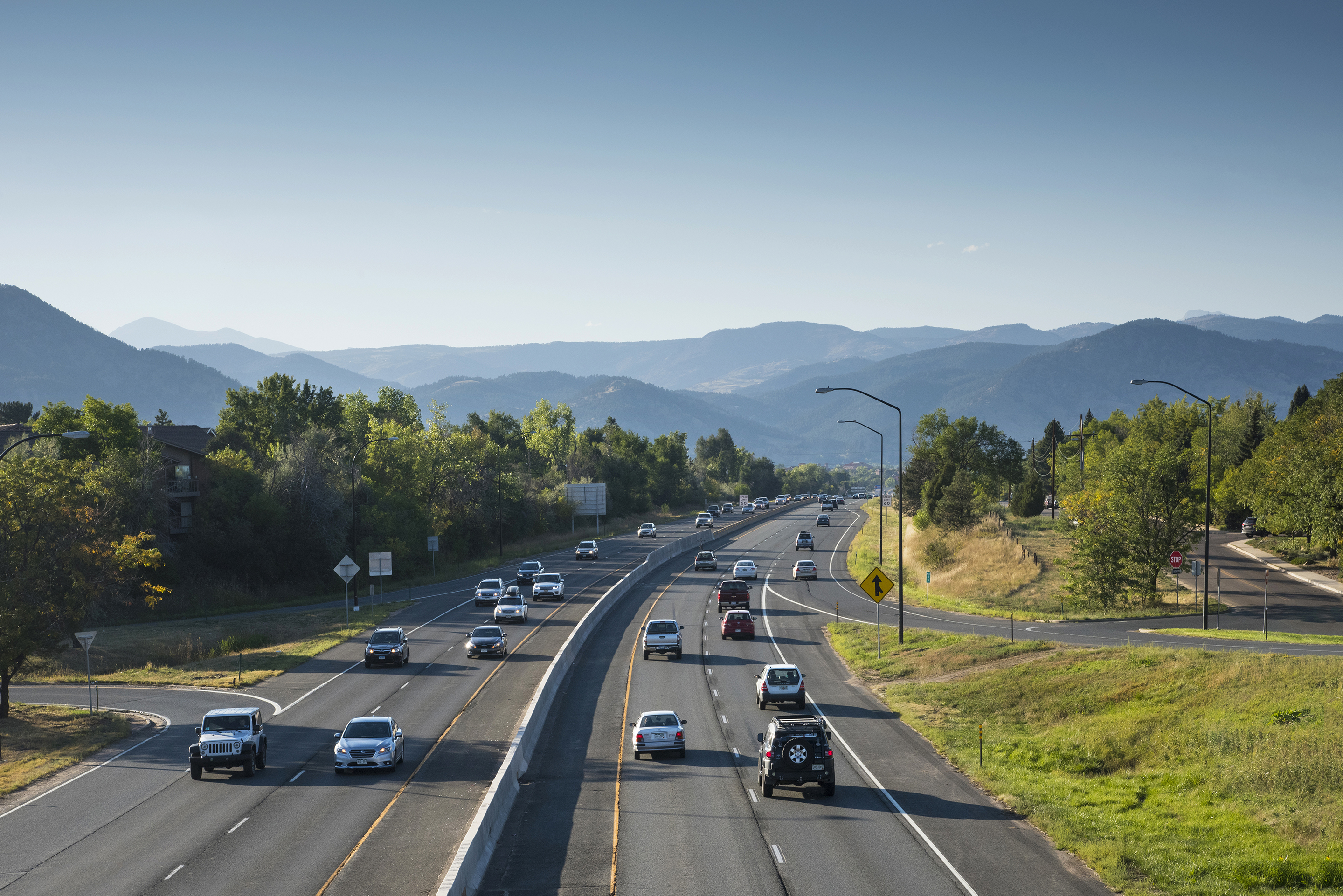 Cars driving on the highway in front of mountains.