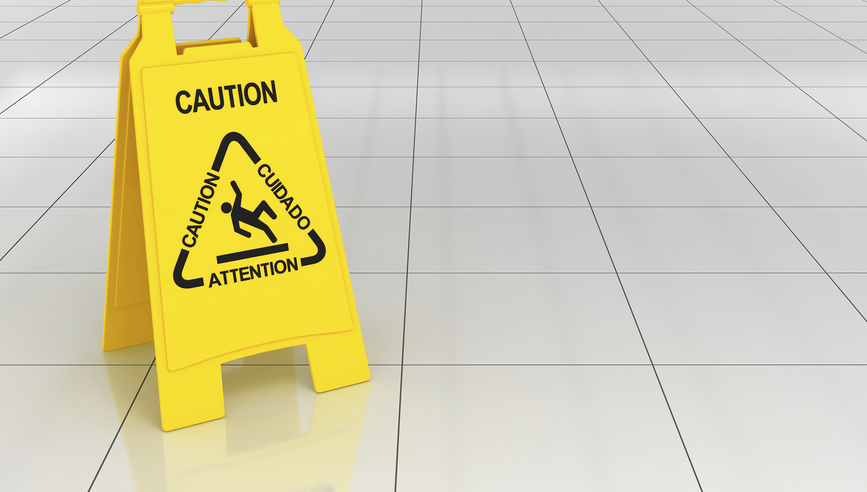 Caution sign warns of a wet, tiled floor.