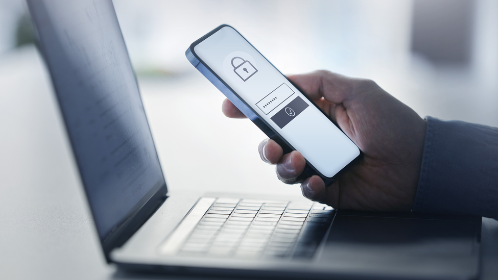 Man holding smart phone with data security on display at office