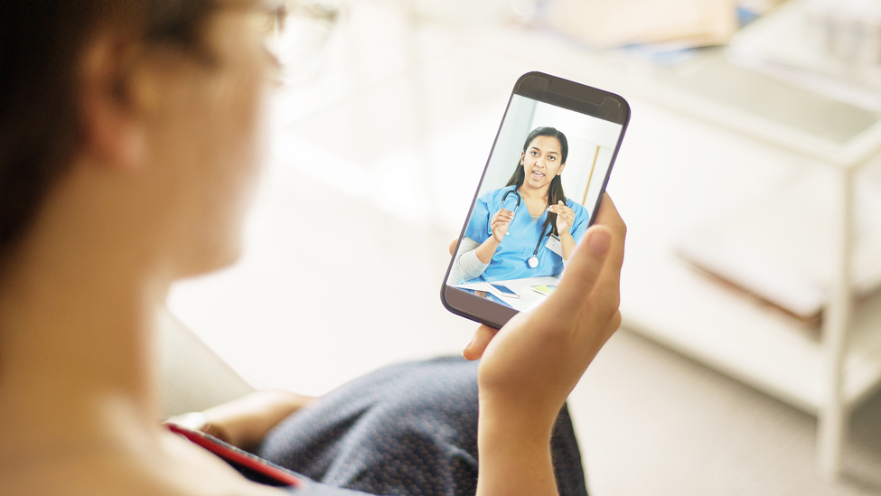 Over the shoulder shot of a patient talking to a doctor using of a mobile phone