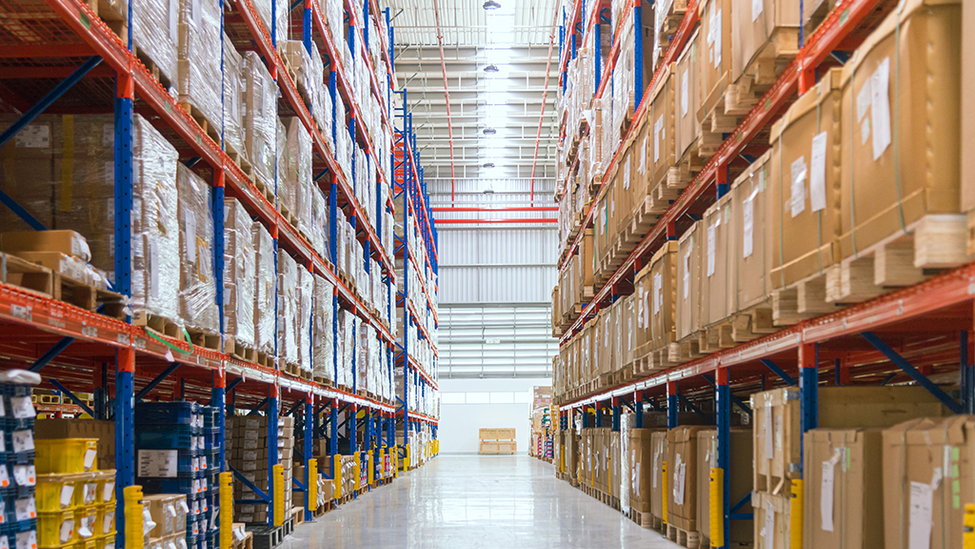 Warehouse facility with shelves full of new product in boxes.