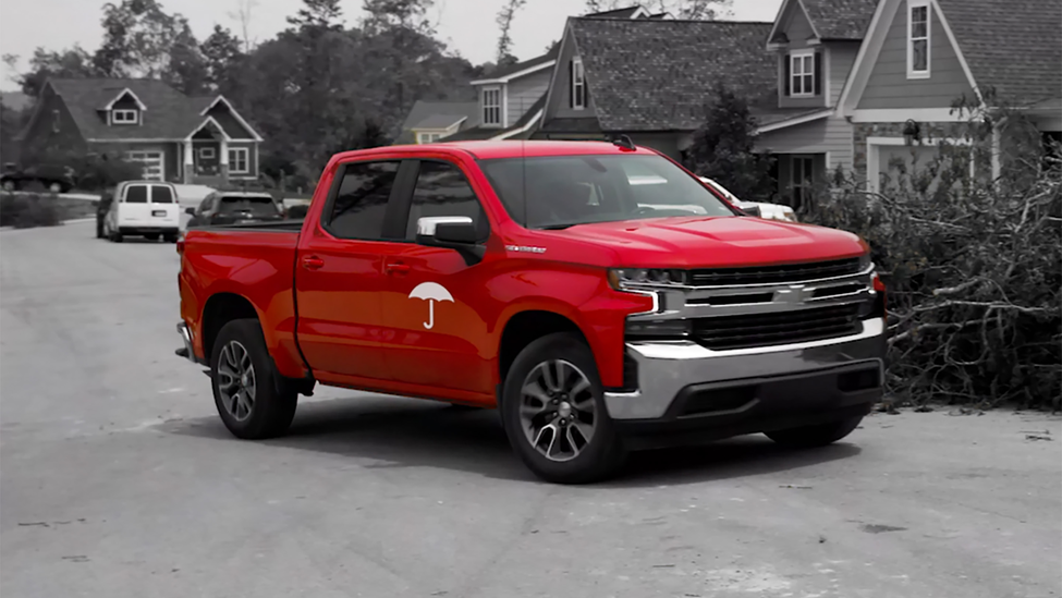 Travelers red pickup truck helping customers after a wildfire.