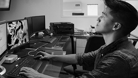 Man at a desk monitoring progress of a storm.