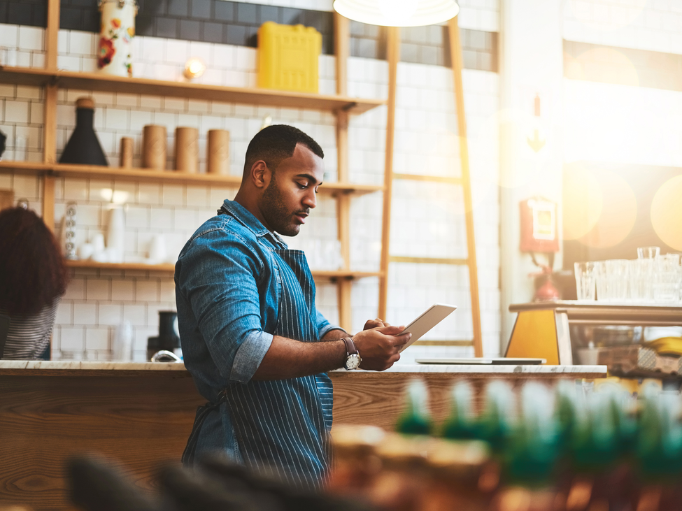 Coffee shop owner working on tablet.