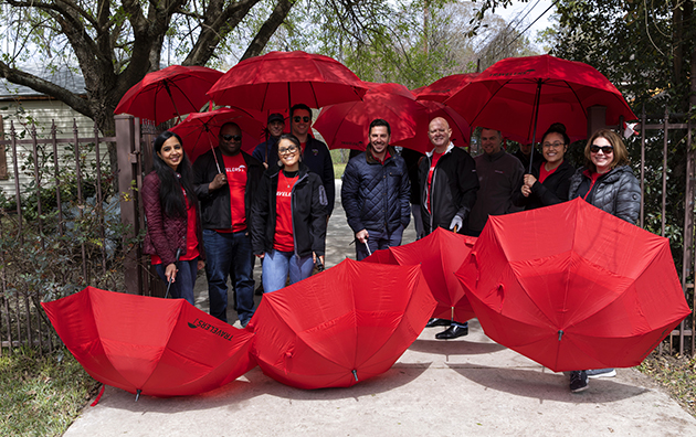 Travelers employees outside with Travelers umbrellas.