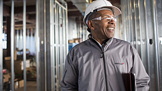 Man wearing a hard hat and Travelers zip up.