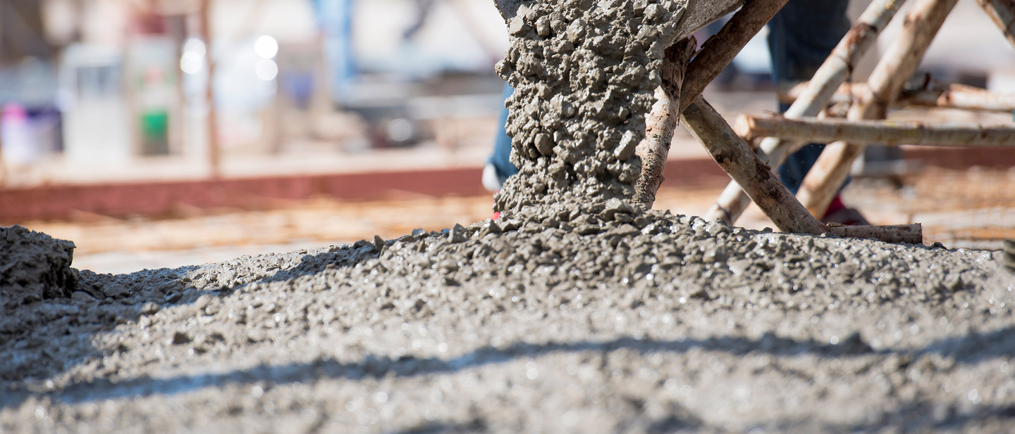 Workers pouring concrete for paving a driveway