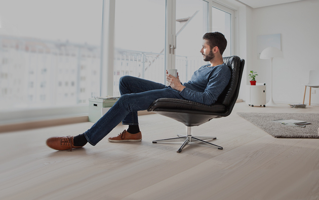 A man sitting down in a chair inside of a condo.