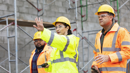 A construction manager with her crew surveying a job site.