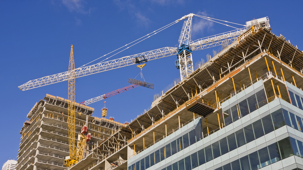 cranes towering above a construction site, construction of a new office building