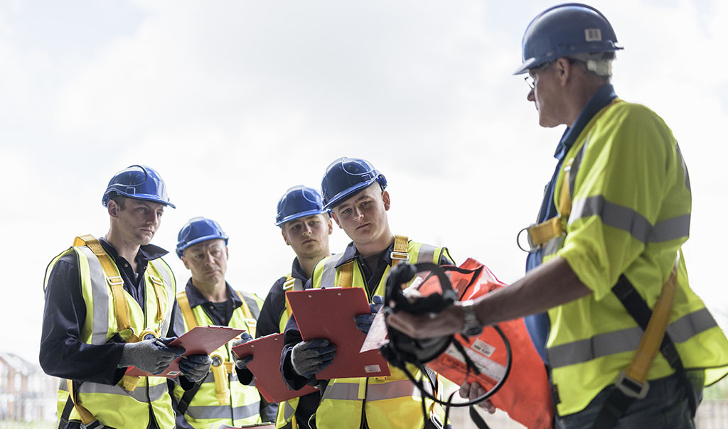 A group of male construction workers having a training on equipment usage