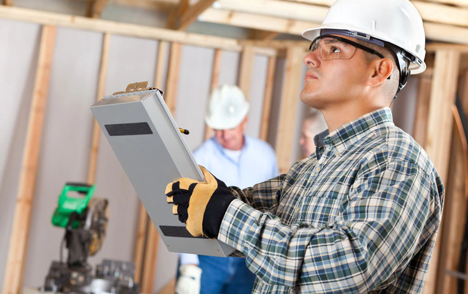 Construction worker inspecting for construction defects.