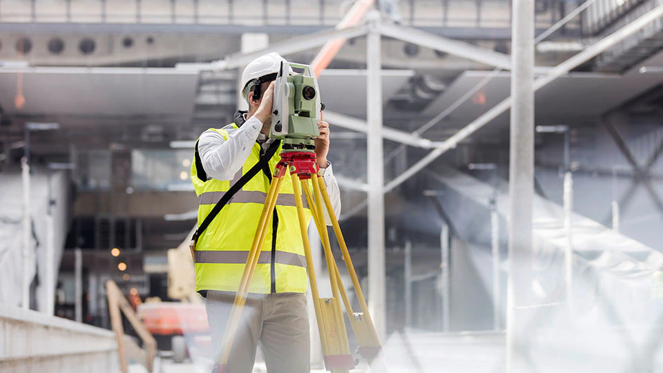 Construction worker surveying site for vibration damage risks.