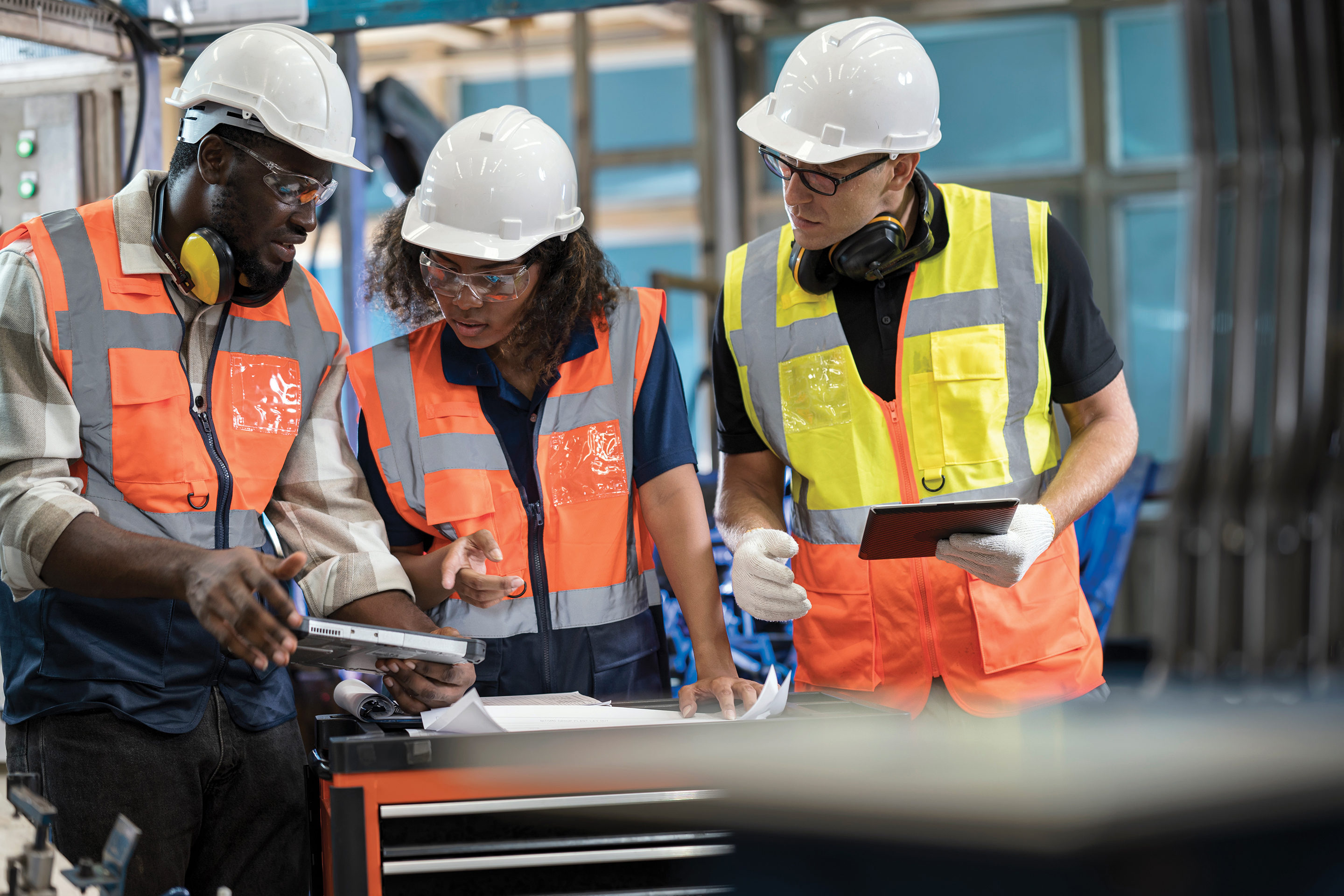 Construction workers having a meeting and looking at paperwork on site.