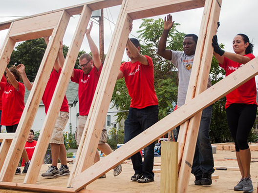 Travelers volunteers help construct a new house.