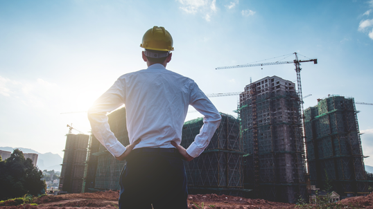 Contractor standing in front of construction site.