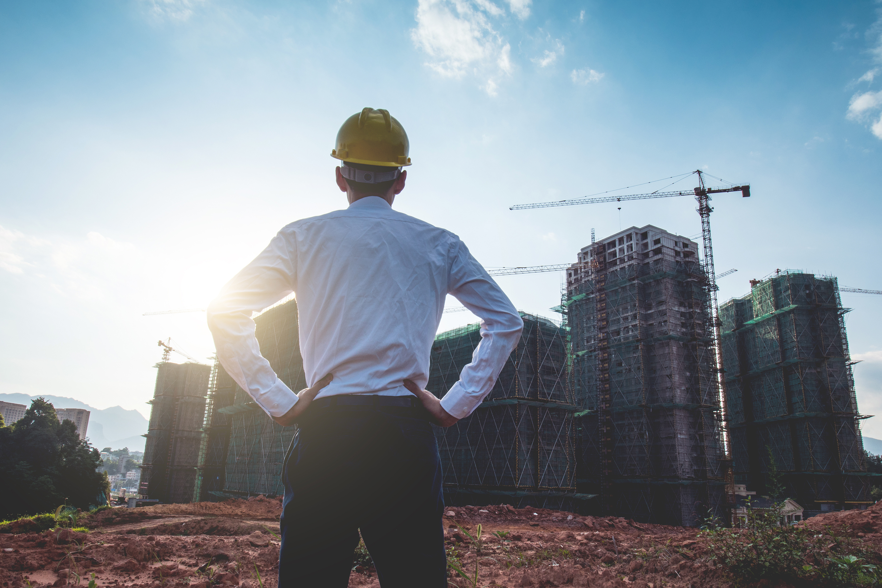 Contractor standing in front of construction site.