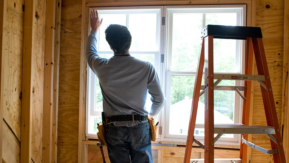 Person working on installing new window in house.