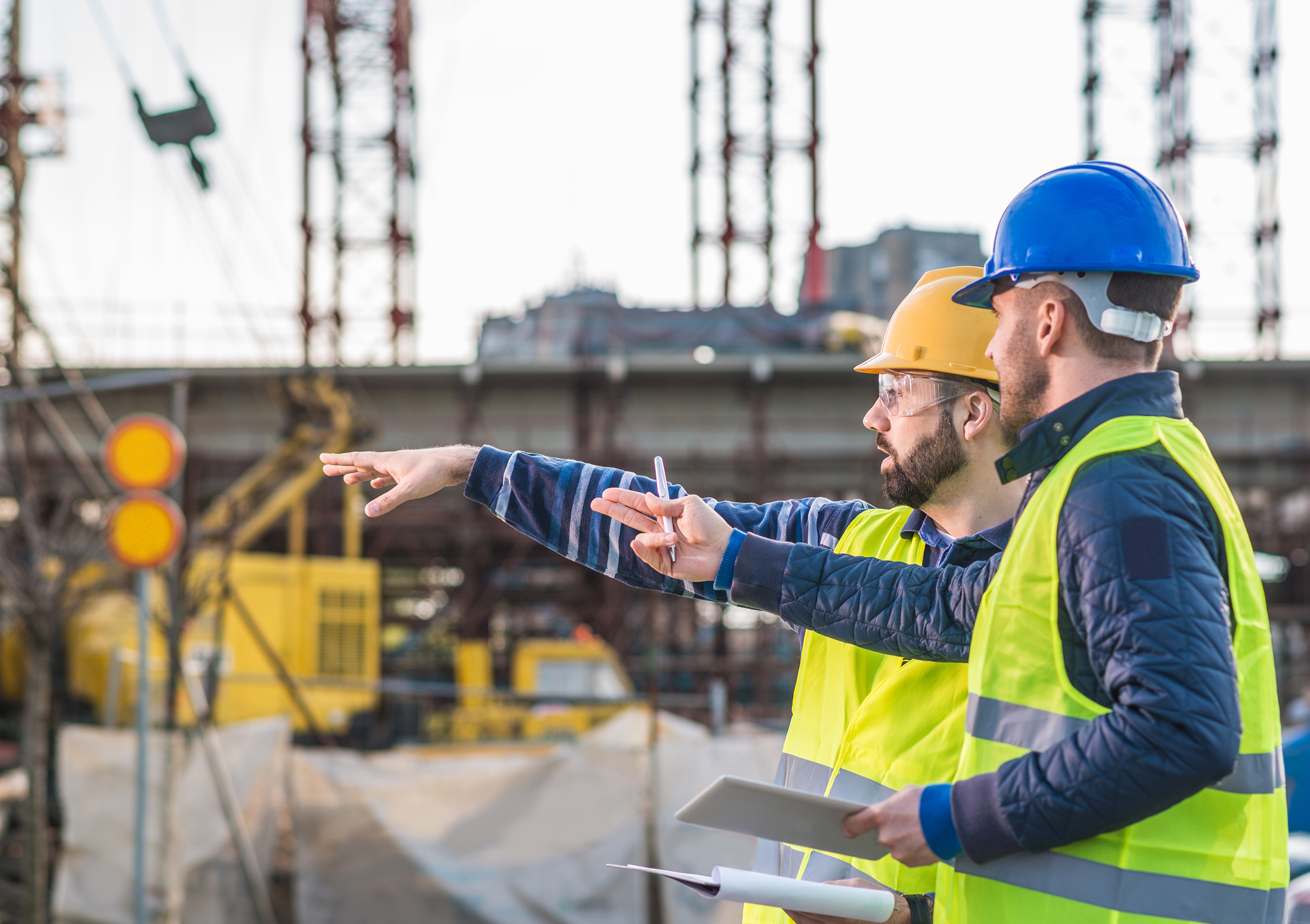 Contractors with blueprints having a meeting on a construction site.