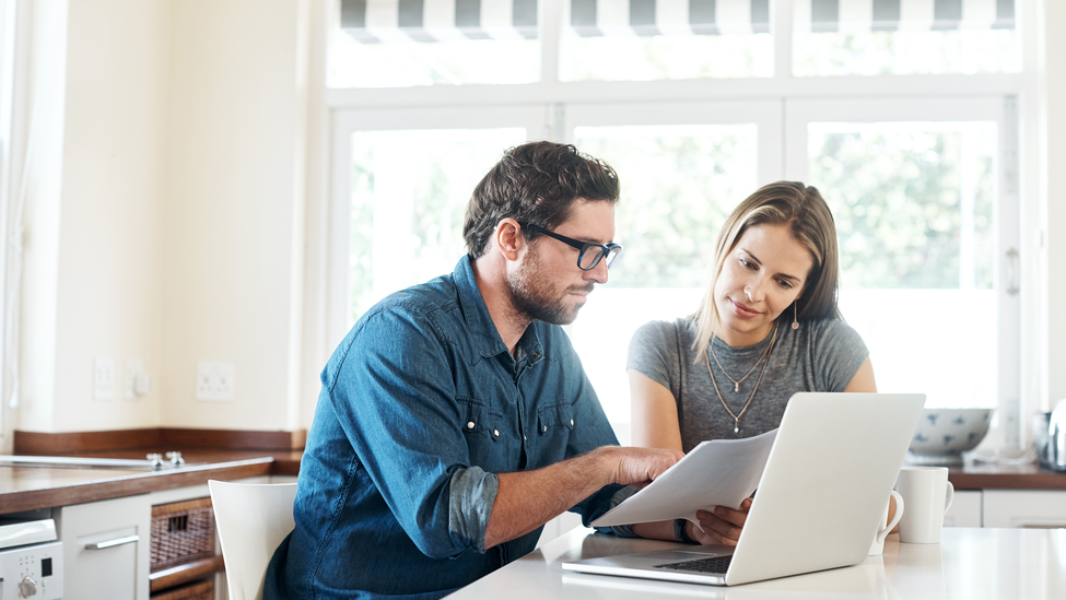 Man and woman comparing home and mortgage insurance.