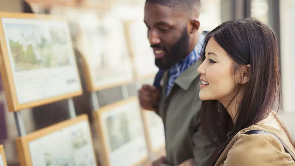 Couple looking at potential houses to buy or rent.