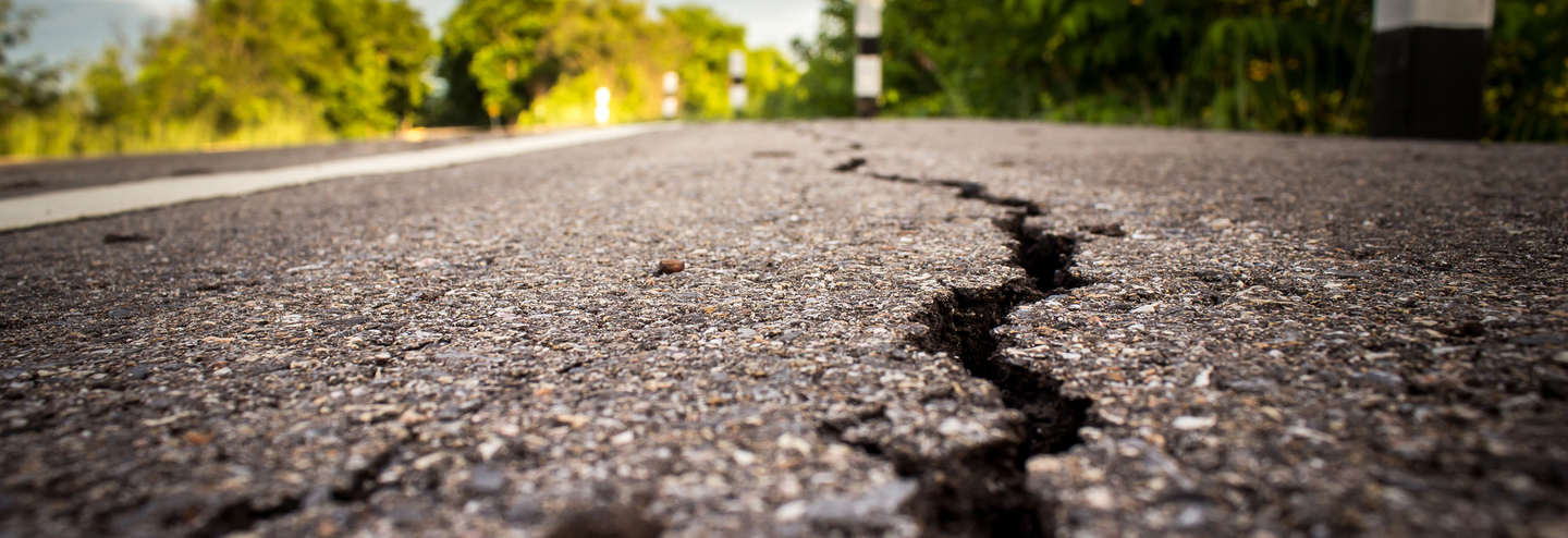 A crack in the road shows evidence of a recent earthquake.