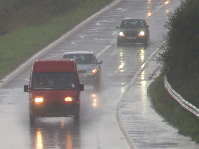 Cars speeding on the highway in the rain and wet roads