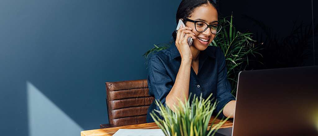 Woman sitting at desk on the phone