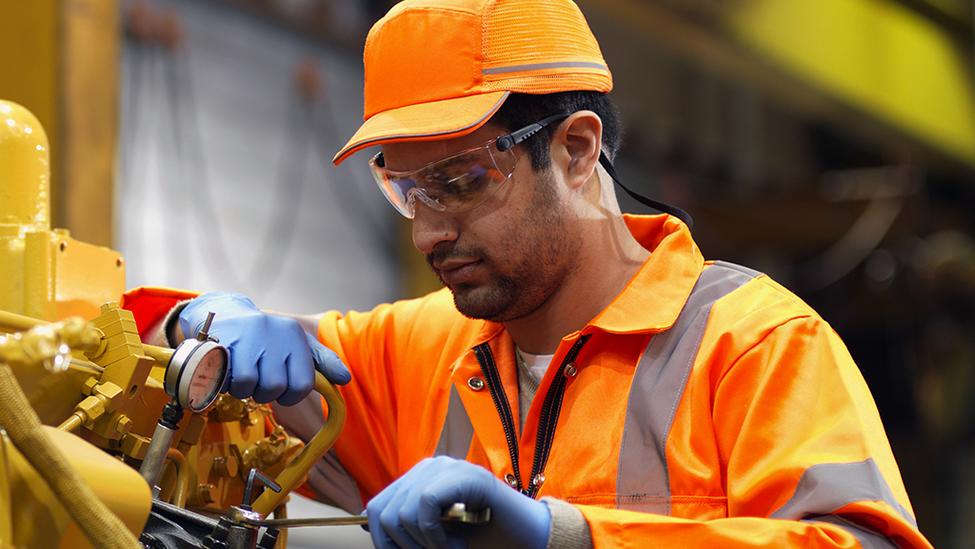 Man working on pipes in factory.