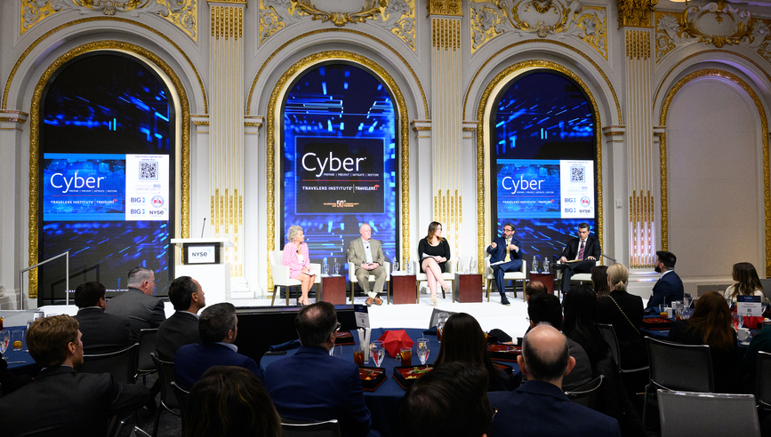 Five people sitting on stage of a Travelers Institute panel.